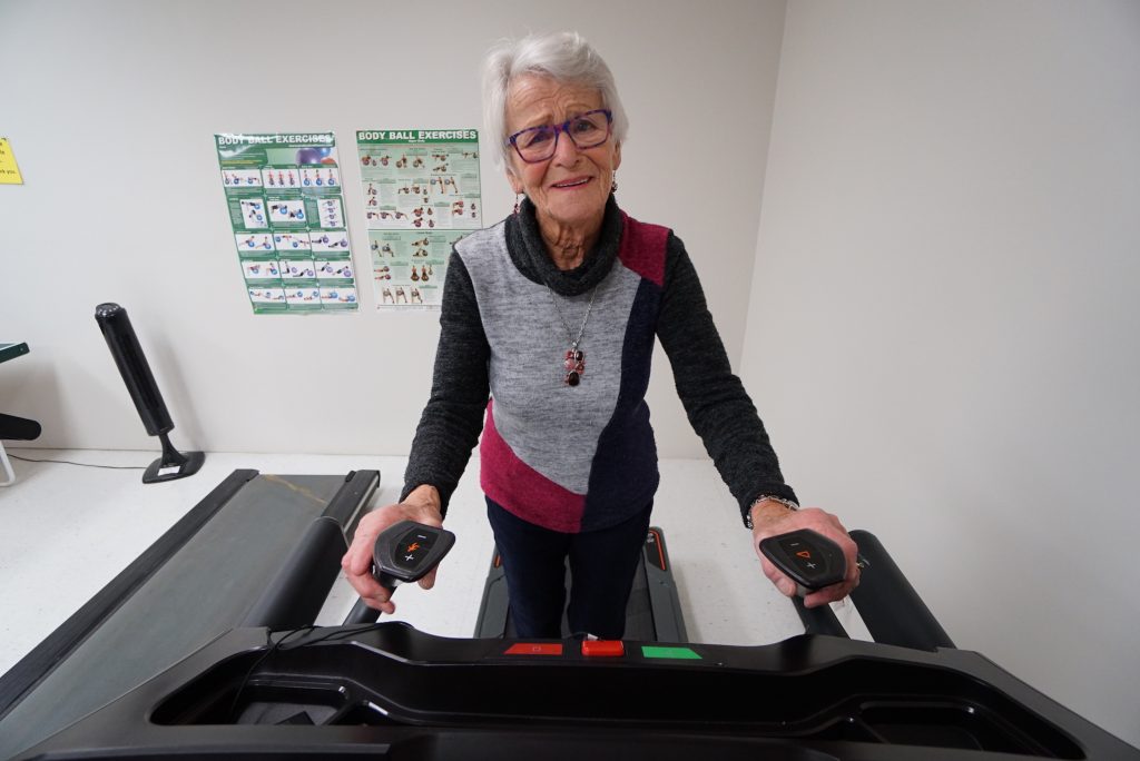 A photo of a elderly woman exercising on a treadmill in Holland Christian Homes Exercise room.