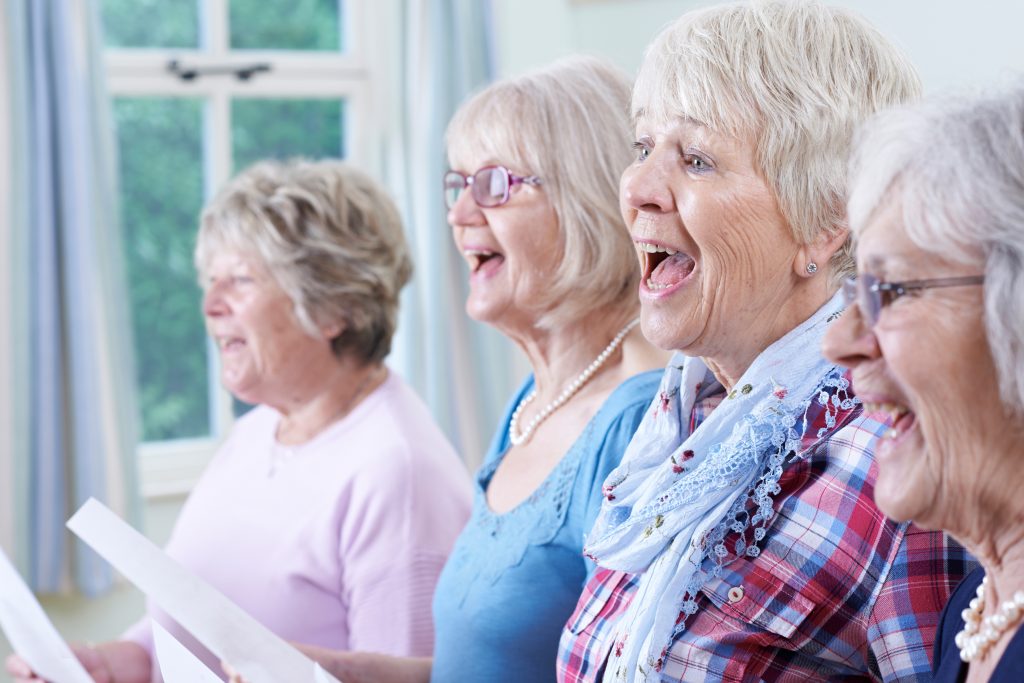 A photo of ladies singing as part of a group activity.