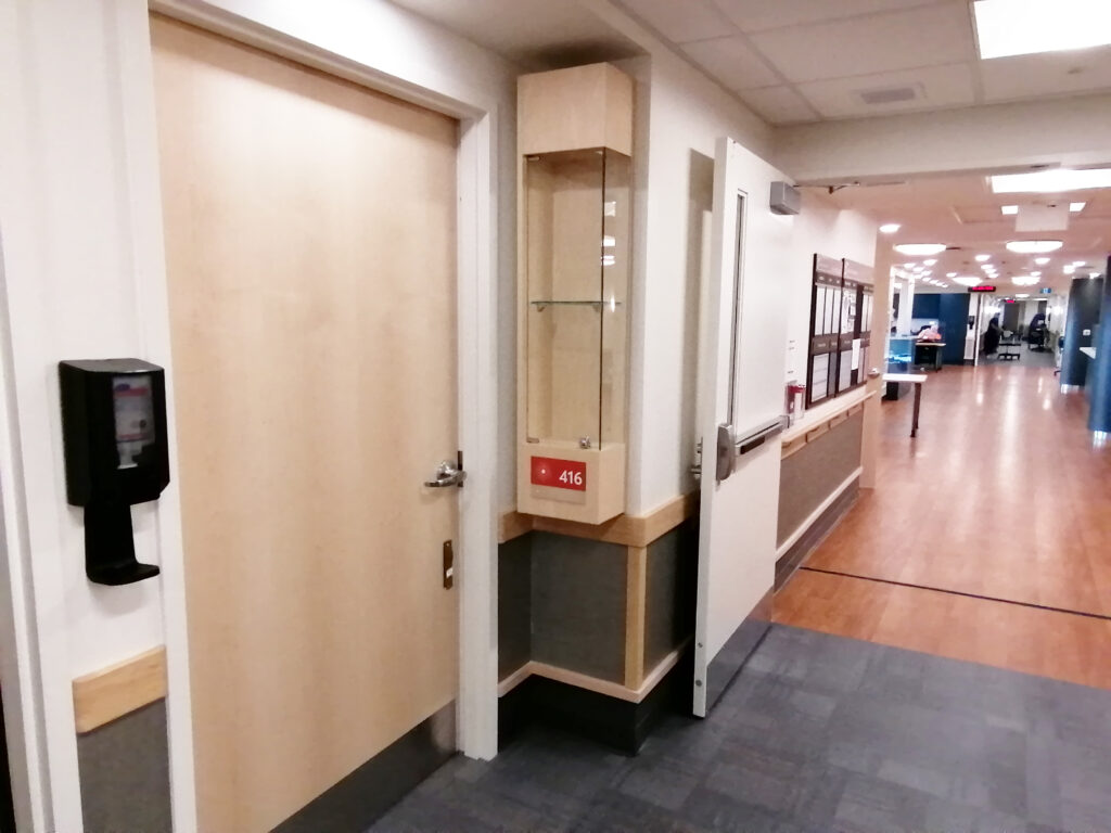 A door to resident room and resident's display case in Faith Manor.